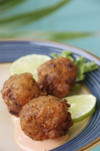 Three deep fried conch fritters, a specialty of the Florida Keys, served with lime and dipping sauce.